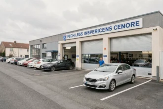 Vue d'ensemble d'un centre de contrôle technique en Gironde avec des voitures en attente devant les baies d'inspection